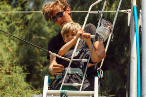 Trapeze instructor holding kid on ladder